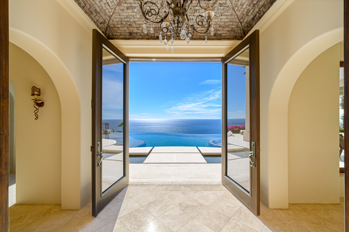 Open doors framing an oceanfront infinity pool and the Sea of Cortez in Palmilla.